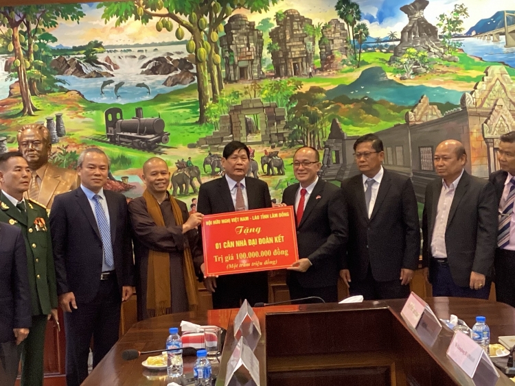 Đoàn công tác Hội hữu nghị Việt Nam - Lào tỉnh Lâm Đồng tặng 100 triệu đồng xây dựng nhà đại đoàn kết ở Champasak, Lào (Ảnh: baolamdong.vn) ຄະນະທິມງານສະມາຄົມມິດຕະພາບຫວຽດນາມ - ລາວ ແຂວງເລີ່ມດົ່ງ ໄດ້ມອບເງິນ 100 ລ້ານດົ່ງ ເພື່ອກໍ່ສ້າງເຮືອນສາມັກຄີ ຢູ່ແຂວງຈຳປາສັກ, ສ ປປ ລາວ (ຮູບພາບ: baolamdong.vn)