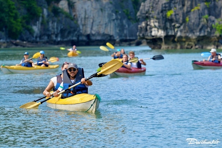 Du khách quốc tế trải nghiệm chèo kayak tại Vung Viêng. (Ảnh: Báo Đại đoàn kết)  ນັກ​ທ່ອງ​ທ່ຽວ​ສາ​ກົນ​ສຳ​ຜັດ​ກັບ​ການ​ພາຍ​ເຮືອ​ກາ​ຢາກ​ຢູ່​ວຸງ​ວຽງ. (ພາບ: ໜັງສືພິມ ມະຫາສາມັກຄີ)