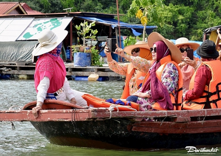 Du khách check-in tại làng chài Vung Viêng. (Ảnh: Báo Đại đoàn kết)  ນັກທ່ອງທ່ຽວເຊັກອິນຢູ່ບ້ານປະມົງວຸງວຽງ. (ພາບ: ໜັງສືພິມ ມະຫາສາມັກຄີ)