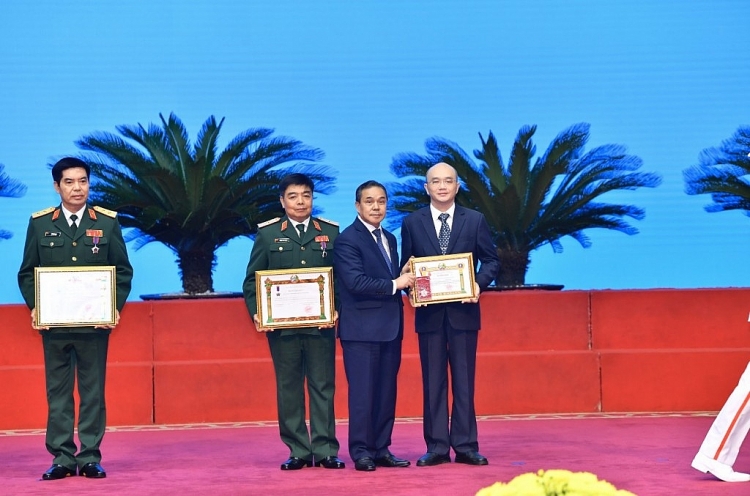 Thừa uỷ nhiệm của Nhà nước Lào, Đại sứ Sengphet Houngboungnuang trao Huân chương Anh dũng hạng Nhất truy tặng cố Thiếu tướng Hoàng Thế Thiện, nguyên Thứ trưởng Bộ Quốc Phòng Việt Nam. Đại diện gia đình Thiếu tướng Hoàng Thế Thiện đón nhận huân chương (ngoài cùng bên phải ảnh).