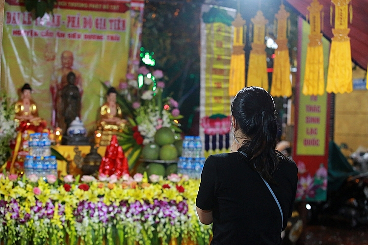 ຮ່າ​ໂນ້ຍ: ປະ​ຊາ​ຊົນ​ນຸ່ງ​ເຄື່ອງກັນ​ຝົນ​ໄປ​ວັດ ຟຸກ​ແຄັງ ເຂົ້າ​ຮ່ວມ​ບຸນເຂົ້າປະດັບດິນ