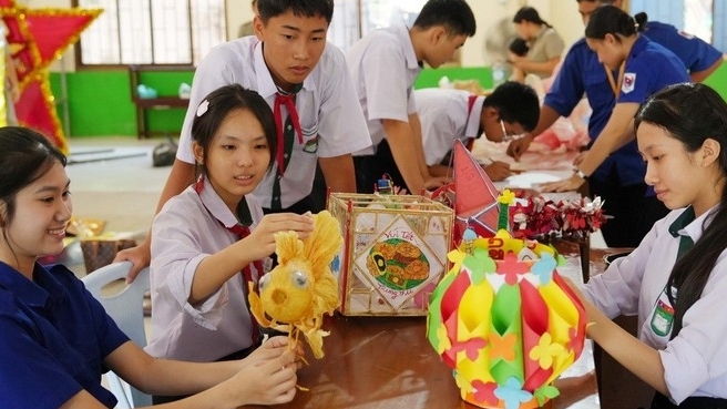 ນັກຮຽນໂຮງຮຽນສອງພາສາ ລາວ – ຫວຽດນາມ ຫງວຽນຢູ ຄຶກຄື້ນເຮັດທຳໂຄມໄຟ ເພື່ອຕ້ອນຮັບວັນບຸນໄຫວ້ພະຈັນ.