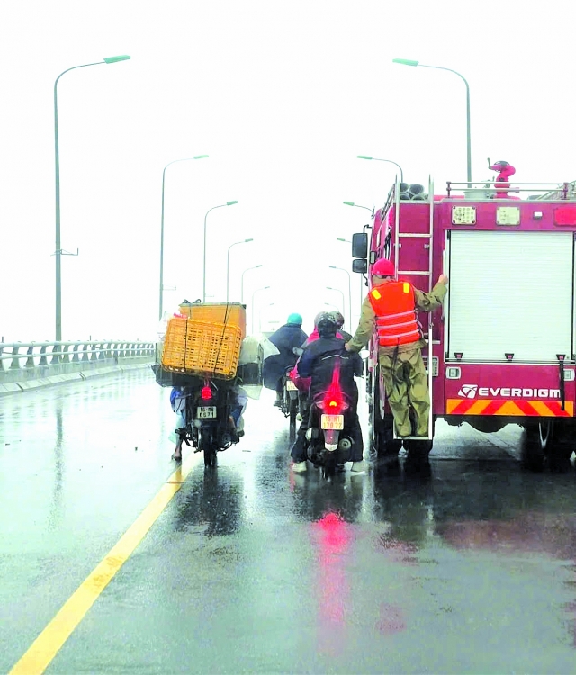 a2 Xe chuyên dụng của lực lượng chức năng hỗ trợ người dân di chuyển qua cầu Khuể - nối huyện Tiên Lãng và An Lão (thành phố Hải Phòng) ngày 7/9/2024. (Ảnh: KT)  a2 ລົດໃຊ້ງານສະເພາະ​ຂອງ​ກອງ​ກຳລັງ​ປະຕິບັດ​ໜ້າ​ທີ່​ໜູນ​ຊ່ວຍ​ປະຊາຊົນ​ເຄື່ອນ​ຍ້າຍ​ຂ້າມ​ຂົວ​ເຄ້ວ-​ເຊື່ອມ​ຕໍ່​ເມືອງ​ຕຽນຫຼາງ ​ແລະ​ເມືອງ​ອານ​ຫຼາວ (ນະຄອນ​ຫ່າຍ​ຟ່ອງ) ​ໃນ​ວັນ​ທີ 7 ກັນຍາ 2024. (ພາບ: KT)