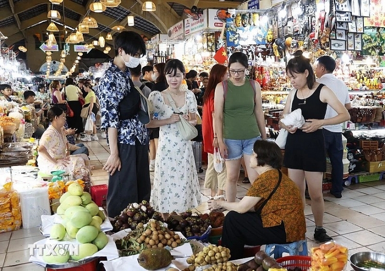 Du khách Hàn Quốc tìm hiểu đặc sản trái cây Nam Bộ trong chợ Bến Thành, Quận 1, Thành phố Hồ Chí Minh. (Ảnh: Hồng Đạt/TTXVN)  ນັກທ່ອງ​ທ່ຽວ ສ.ເກົາຫຼີ ໄດ້​ຮຽນ​ຮູ້​ກ່ຽວ​ກັບ ໝາກ​ໄມ້​ພິເສດຂອງພາກ​ໃຕ້​ພິ​ເສດ​ຢູ່​ຕະ​ຫລາດ​ເບນ​ແທ່ງ, ເຂດ 1, ນະ​ຄອນ ໂຮ່​ຈິ​ມິນ. (ພາບ: ຮົ່ງດາດ/ສໍານັກຂ່າວຫວຽດນາມ)