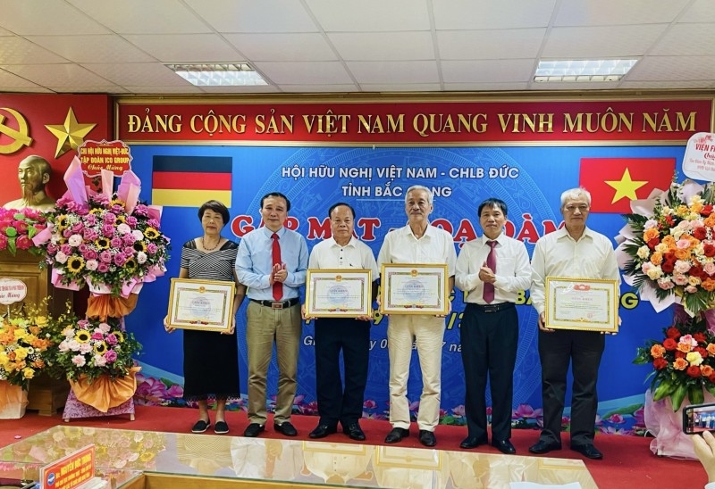 Ông Nguyễn Đức Trọng, Phó Chủ tịch Thường trực - Tổng Thư ký LHHN tỉnh và ông Nguyễn Cường, Chủ tịch Hội trao Giấy khen cho các cá nhân. ທ່ານ ຫງວຽນດຶກຈອ້ງ, ຮອງປະທານຜູ້ປະຈໍາການ - ເລຂາທິການໃຫຍ່ ສະຫະພັນບັນດາອົງການຈັດຕັ້ງມິດຕະພາບຫວຽດນາມແຂວງ ແລະ ທ່ານ ຫງວຽນເກືອງ ປະທານສະມາຄົມ ໄດ້ມອບໃບຍ້ອງຍໍໃຫ້ແກ່ບຸກຄົນ.